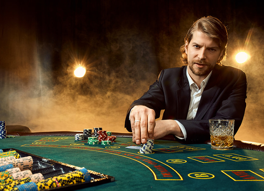 Eine Person sitzt mit Spielchips und Karten an einem Pokertisch und bereitet sich auf ein Spiel vor.